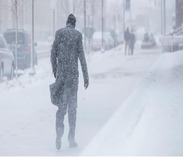 A man walks through a winter storm