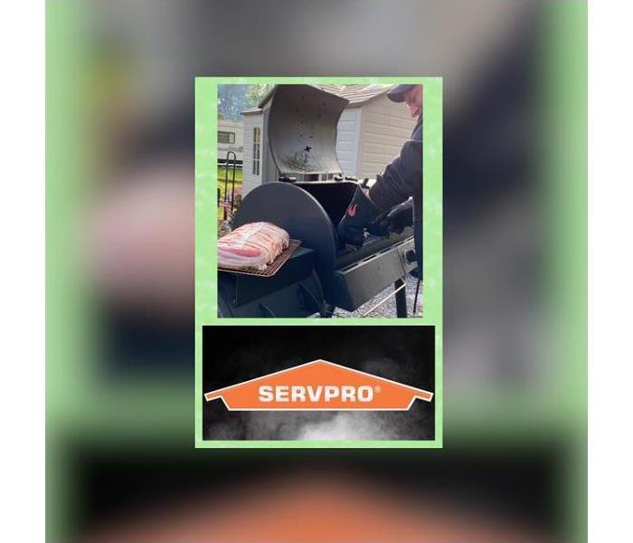 The photo shows a man cooking non a grill with the SERVPRO logo below it.