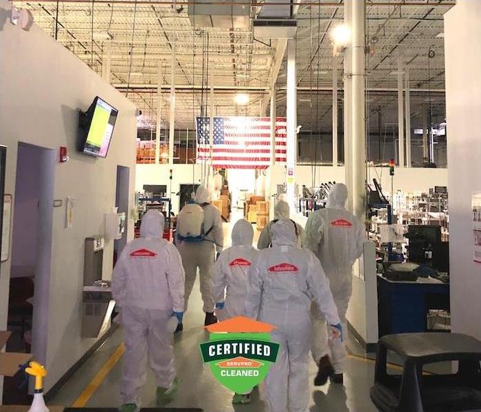 A photo of SERVPRO technicians walking into a commercial building ready to disinfect for Covid19